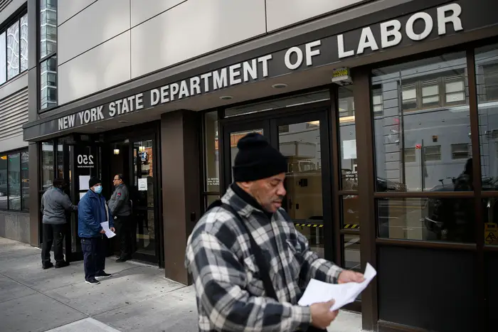 Visitors to the Department of Labor are turned away at the door by personnel due to closures over coronavirus concerns, in New York. Applications for jobless benefits are surging in some states as coronavirus concerns shake the U.S. economy.